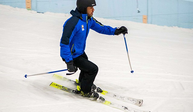 Shot of man in blue jacket and black trousers skiing down the slope at Chill Factor<sup>e</sup>