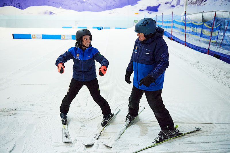 Female skier talking to ski instructor while doing a snowplough at Chill Factor<sup>e</sup>