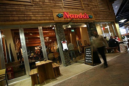 The shopfront of the Nandos restaurant situated inside chill factore in Manchester, UK