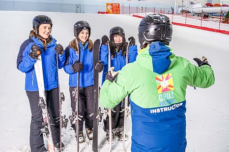 a group of people in ski gear stood on with their skis and snowboards inside chill factore