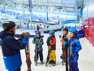 Group of children in ski gear at Chill Factor<sup>e</sup> having a briefing from an instructor