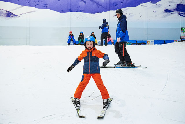 Child skiing down the beginner slope at Chill Factor<sup>e</sup> in a snow plough position
