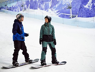 Snowboarder on the slope with an instructor at Chill Factor<sup>e</sup>