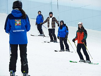 Skiers stood in a line while on a ski lesson at Chill Factor<sup>e</sup>