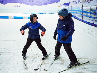 Female skier talking to ski instructor while doing a snowplough at Chill Factor<sup>e</sup>