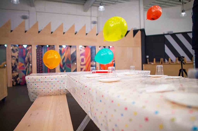 a room set up for a birthday party with a wall with a geometric ski pattern on it