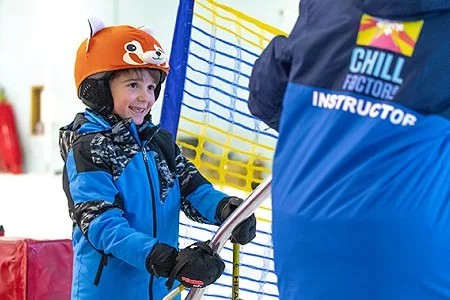 A young boy stood in the snow wearing a blue chill factore jacket