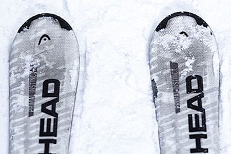 Close up of the tip of a pair of skis, they have the word 'head' written on them in Black.