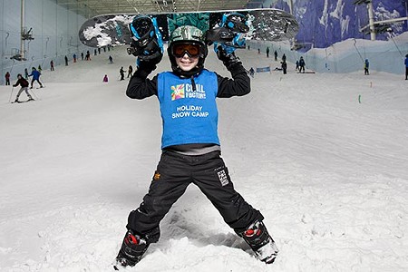 Child in ski gear looking to camera. Stood on snow slope at Chill Factor<sup>e</sup>