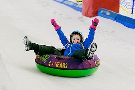 Child sliding down a donut lane in an inflatable donut